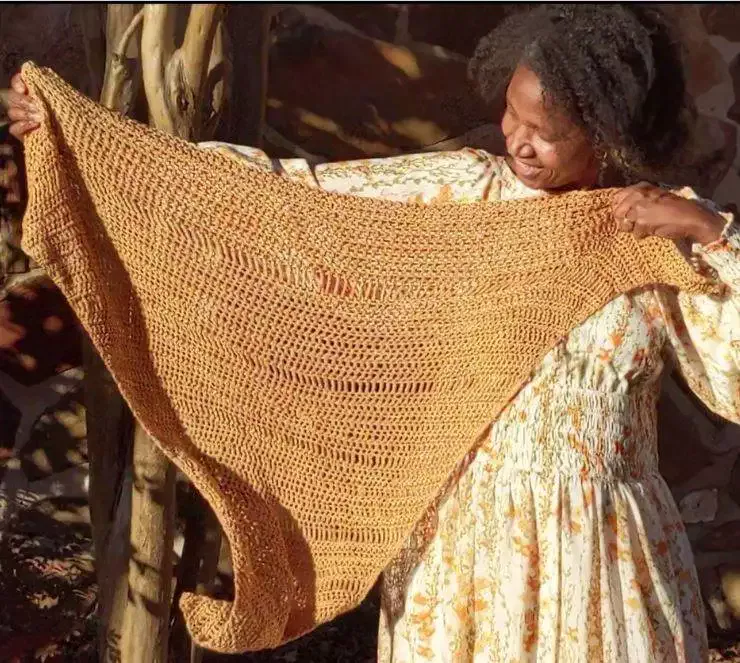 Woman flapping triangle shawl in the wind.